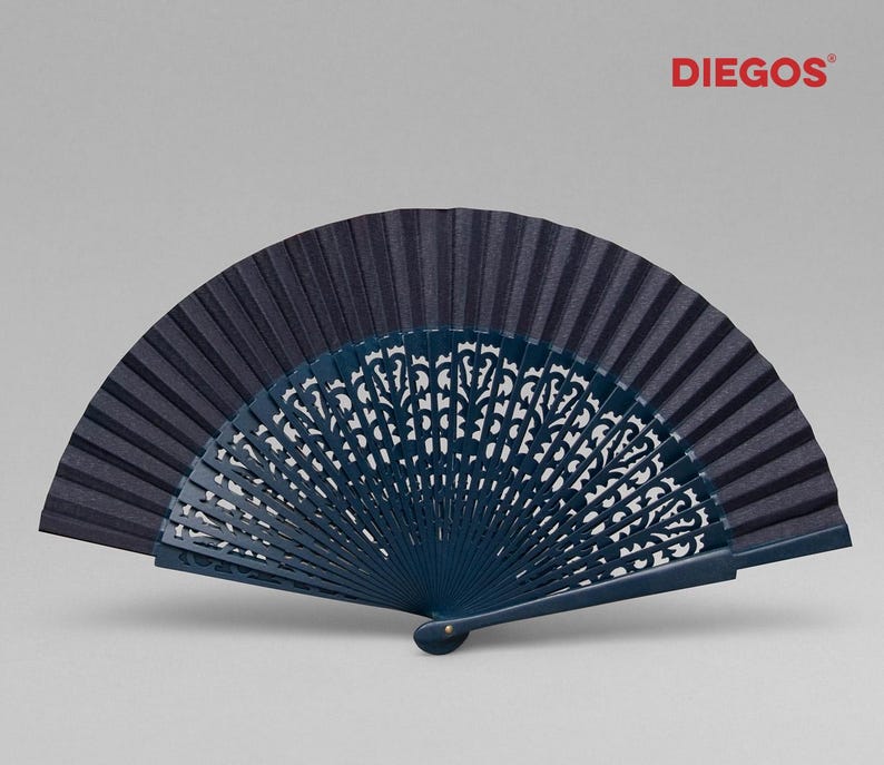 May include: A dark blue hand fan with a decorative, intricate, carved design. The fan is made of wood and fabric.
