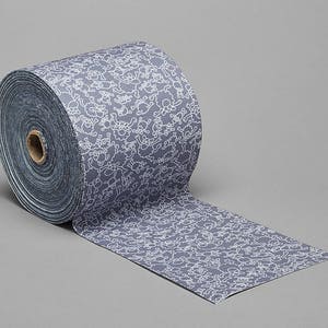 May include: A roll of gray patterned fabric with a white design of sheep. The fabric is rolled up and the end of the roll is unfurled.