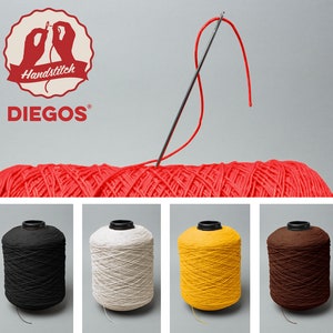 May include: Four spools of thread in black, white, yellow, and brown. The spools are on a white surface. The image also shows a needle and red thread.