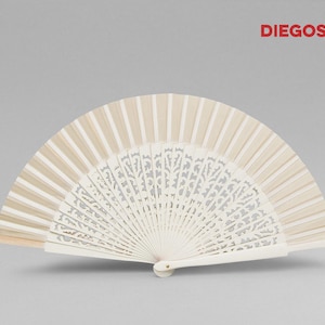 May include: A white hand fan with a delicate, intricate floral design. The fan is made of wood and has a beige color.