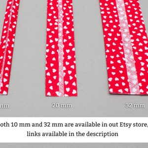 May include: Three red fabric strips with white heart patterns. The strips are 10 mm, 20 mm, and 32 mm wide. Both 10 mm and 32 mm are available in our Etsy store, links available in the description.