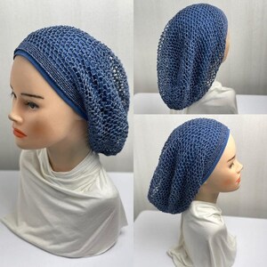 Op de afbeelding: Een blauwe gehaakte hoed met een effen blauwe band wordt getoond op een mannequinhoofd. De hoed heeft een los, open geweven ontwerp. De mannequin draagt een witte top.