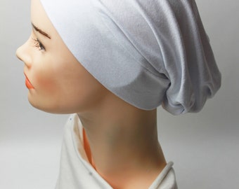 May include: White cotton jersey beanie hat. The hat is soft and stretchy, and it can be worn in a variety of ways.
