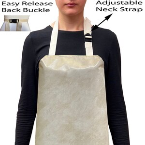 May include: A beige apron with adjustable neck straps and an easy release back buckle. The apron is made of a water-resistant material.