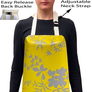 May include: Yellow waterproof apron with a floral pattern in grey. The apron has an adjustable neck strap and an easy release back buckle.
