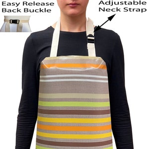 May include: A brown and beige striped apron with a white olive branch design. The apron has adjustable neck straps and an easy release back buckle.