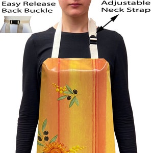May include: A yellow and orange striped apron with a sunflower and olive branch design. The apron has adjustable neck straps and an easy release back buckle.