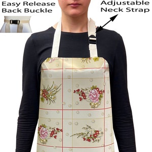 May include: A beige apron with a floral pattern and adjustable neck strap. The apron has an easy release back buckle.