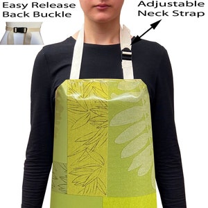 May include: A green and white patterned apron with adjustable neck straps and an easy release back buckle. The apron has a leafy design.