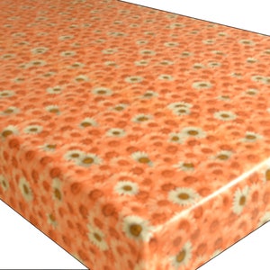 May include: Orange tablecloth with a white daisy pattern. The tablecloth is made of vinyl and is waterproof.