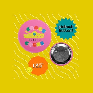 May include: Pink 1.25 inch pinback button with a cartoon illustration of a yellow and blue Croc shoe with flowers and the text "Crocs before socks".