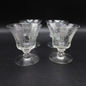May include: Set of four clear glass stemmed dessert dishes with an etched floral design.