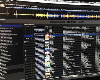 May include: A computer screen displaying a DJ software interface. The screen shows waveforms, playlists, and track information. The software includes a collection of music tracks and playlists, including "HOT DANCE COUNTRY TRACKS" and "SLOW JAMS 2020".
