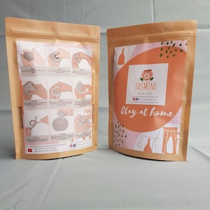 May include: A brown paper bag with a white label that has instructions for making a clay pot. The label also includes the text "Jasmine Pottery Studio" and "Clay at Home".