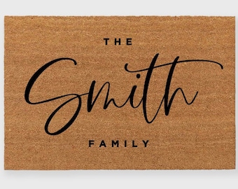 May include: A brown coir doormat with the text "The Smith Family" in black cursive lettering.