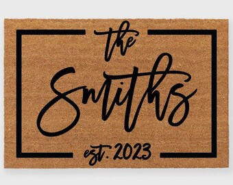 May include: A brown coir doormat with a black frame and the text "The Smiths est. 2023" in a cursive font.