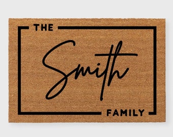 May include: A brown coir doormat with a black border and the text "THE Smith FAMILY" in a script font.