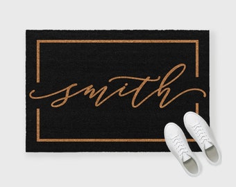 May include: Black doormat with a gold frame and the word "smith" written in cursive script.