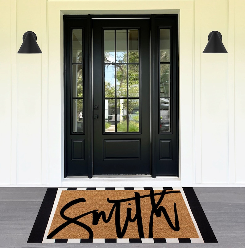 May include: A brown coir doormat with black and white stripes around the edges. The word "Smith" is written in black cursive lettering on the mat.