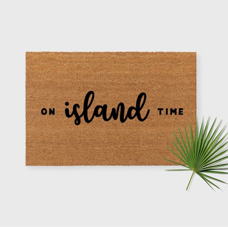 May include: A brown coir doormat with the text "ON island TIME" in black lettering.