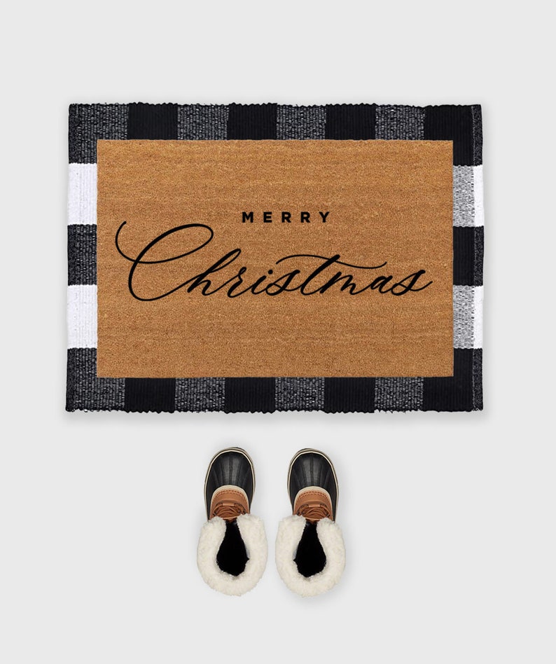 May include: A black and white checkered doormat with the text "Merry Christmas" in a cursive font. Two brown and black winter boots are placed in front of the doormat.