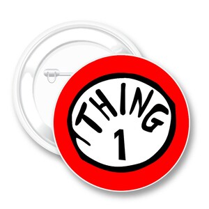 May include: A round button pin with a red border and the words "THING 1" in black on a white background. The pin has a safety pin back and a white plastic backing. The design is reminiscent of a popular children's book.
