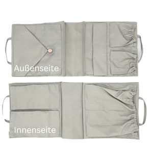 May include: A gray fabric organizer with multiple pockets and a drawstring closure. The organizer is shown open, revealing the inside pockets. The text "Au&szlig;en seite" is printed on the outside of the organizer and "Innen seite" is printed on the inside.