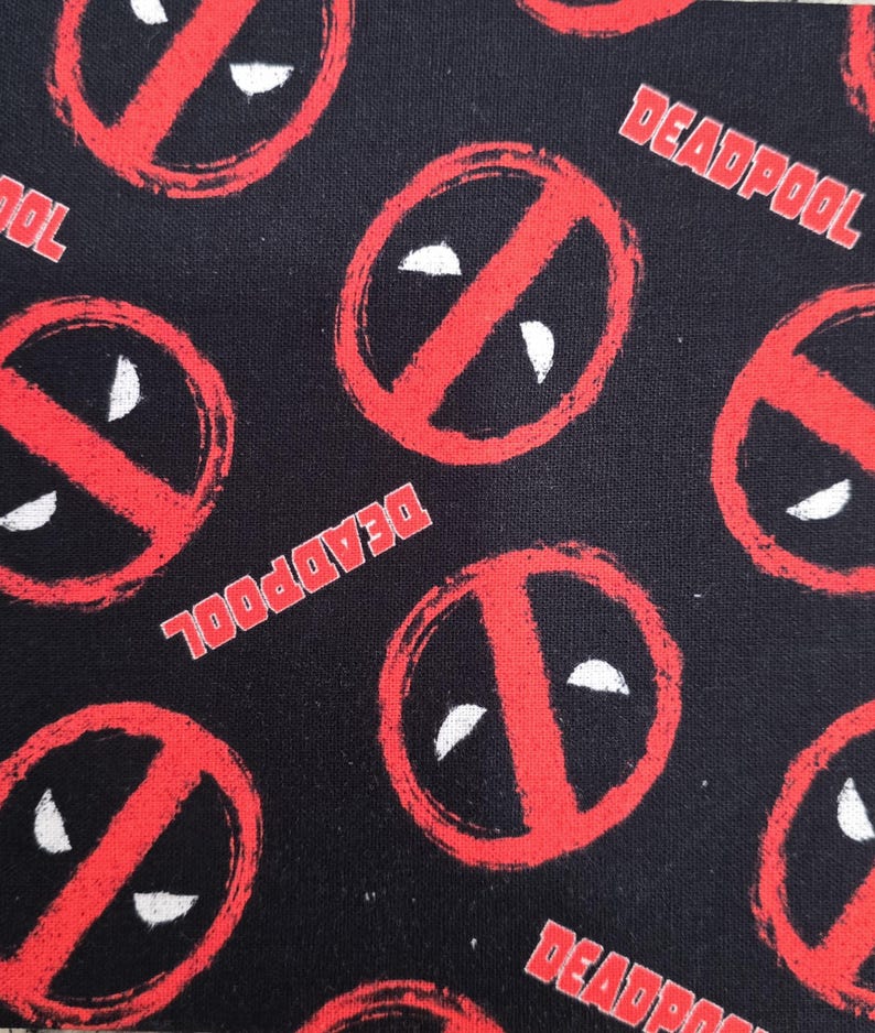 May include: A black fabric featuring a repeating pattern of the red Deadpool logo, which consists of a red circle with a diagonal slash and two white eye shapes. The word DEADPOOL is printed in red capital letters throughout the fabric design.