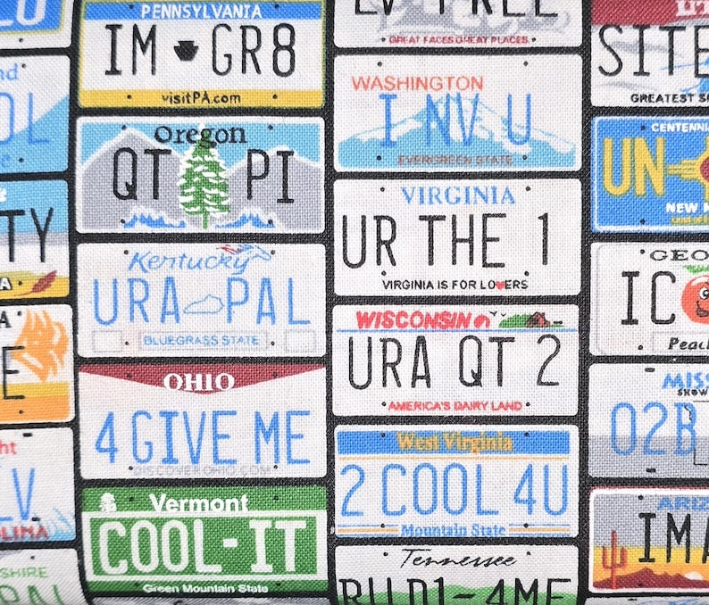 May include: A fabric pattern featuring a collage of various United States license plates with text including IM GR8, I NV U, UR THE 1, URA QT 2, 4 GIVE ME, 2 COOL 4U, and COOL-IT. The design displays colorful state names, slogans, and graphics.