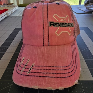 May include: Pink and black mesh trucker hat with a white embroidered Jeep Renegade logo.