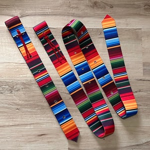 May include: Three colorful woven belts with a red, blue, green, and yellow pattern. The belts are made of a thick, durable material and have a unique, handmade look.