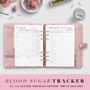May include: A printable blood sugar tracker in a pink binder. The tracker has sections for meals, blood sugar readings, and notes. The text on the page reads "Daily Blood Sugar Tracker" and "Blood Sugar Tracker".