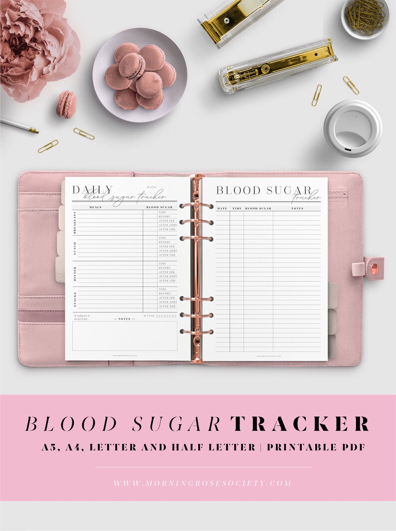 May include: A printable blood sugar tracker in a pink binder. The tracker has sections for meals, blood sugar readings, and notes. The text on the page reads "Daily Blood Sugar Tracker" and "Blood Sugar Tracker".