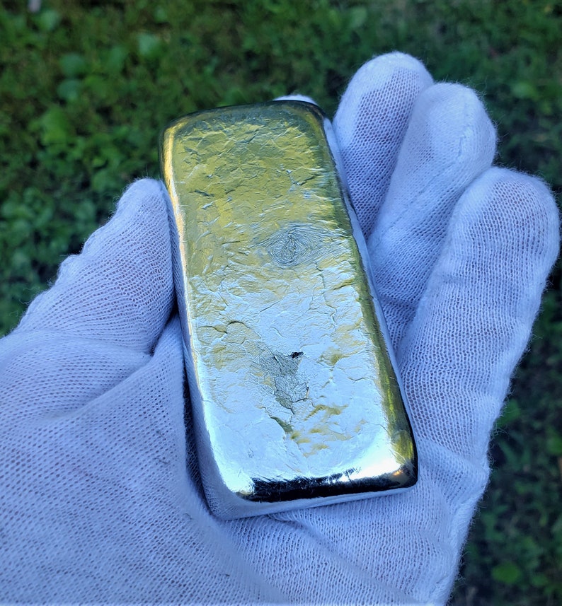 May include: A silver bar with a textured surface. The bar is rectangular and has a shiny, metallic finish.