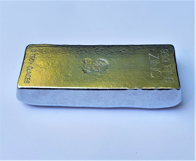 May include: A silver bar of zinc with the text "99.9 FINE ZINC" and "10 TROY OUNCES" on the side.