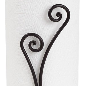 May include: Black metal paper towel holder with a decorative scroll design. The holder has a round base and a hook at the top.