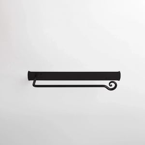 May include: Black metal wall-mounted paper towel holder with a decorative scroll design.