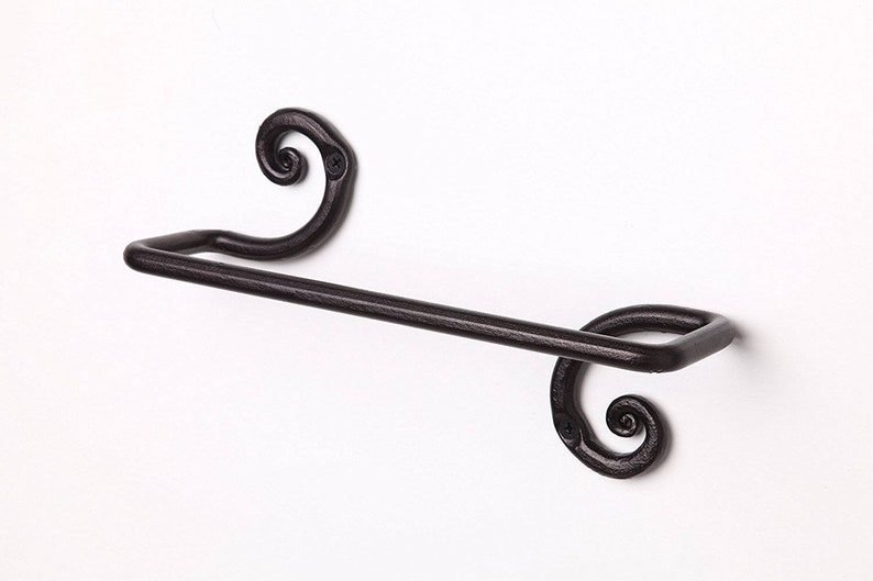 May include: Black metal towel rack with decorative scrollwork on the ends. The rack is mounted to a white wall.