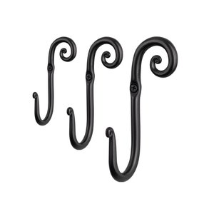May include: Three black metal hooks with a decorative scroll design. The hooks are mounted on a white background.