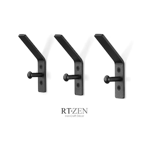 May include: Three black metal wall hooks with a minimalist design. Each hook has a rectangular backplate, a curved arm, and a rounded knob. The hooks are mounted on a white background. The text "RT-ZEN Iron-Craft Décor" is below the hooks.