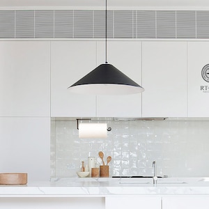 Pode incluir: Uma cozinha branca com arm&aacute;rios brancos, uma luz pendente preta e um backsplash de azulejos brancos. Uma tigela de madeira est&aacute; na bancada. O texto "RT ZEN Iron Craft Decor" &eacute; vis&iacute;vel na parede.