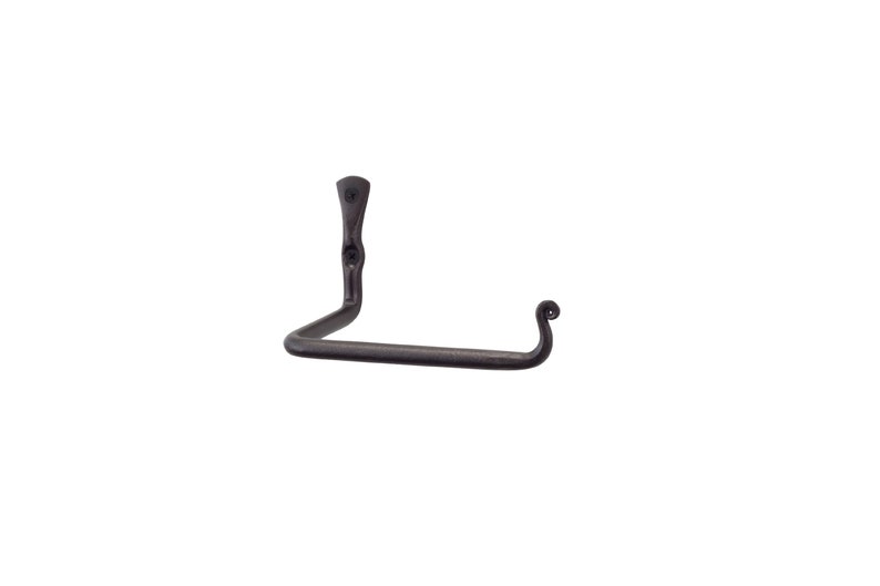 May include: A black metal toilet paper holder with a curved arm and a decorative scroll design at the end. The holder is mounted to a wall.