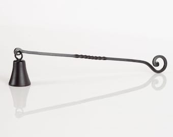 May include: A black metal candle snuffer with a bell-shaped top and a twisted handle that ends in a curl.