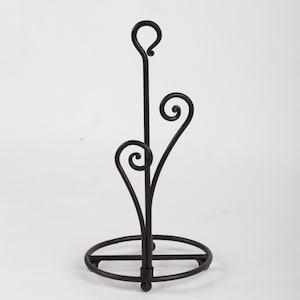May include: Black metal paper towel holder with a round base and a decorative swirl design.