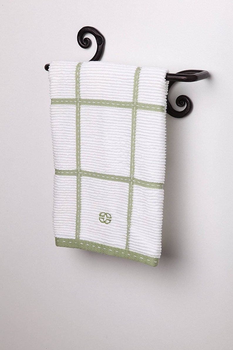May include: A black wrought iron towel rack with a decorative scroll design. A white and green striped kitchen towel is hanging on the rack.