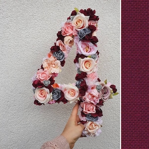 Könnte beinhalten: Eine große, als Zahl vier geformte Dekoration, die mit künstlichen Blumen in den Farben Burgunderrot, Altrosa, Creme und Grau bedeckt ist. Das florale Arrangement besteht aus dicht angeordneten Rosen- und Hortensienblüten in dieser Ziffer.