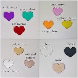 May include: Assortment of heart-shaped acrylic mirrors in various colors, including purple, green, red, orange, yellow, pink, gold, rose gold, silver, clear, black, and wood.