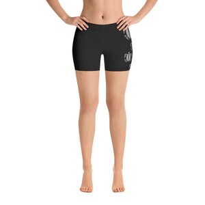 May include: Black athletic shorts with a white graphic print of sea turtles on the right leg.