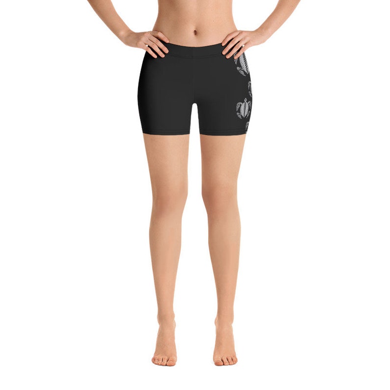 May include: Black athletic shorts with a white graphic print of sea turtles on the right leg.