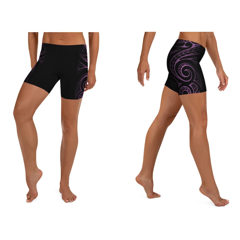 May include: Black athletic shorts with a purple tribal design. The shorts are form-fitting and feature a swirling pattern on the side. The shorts are designed for athletic activities and are made of a stretchy material.